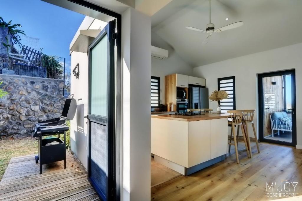 una cucina a pianta aperta e una sala da pranzo con vista su una casa di Villa Azur Saint-Gilles - La Réunion - Seaview, Pool, Beach & BBQ! a Saint-Gilles-les Bains