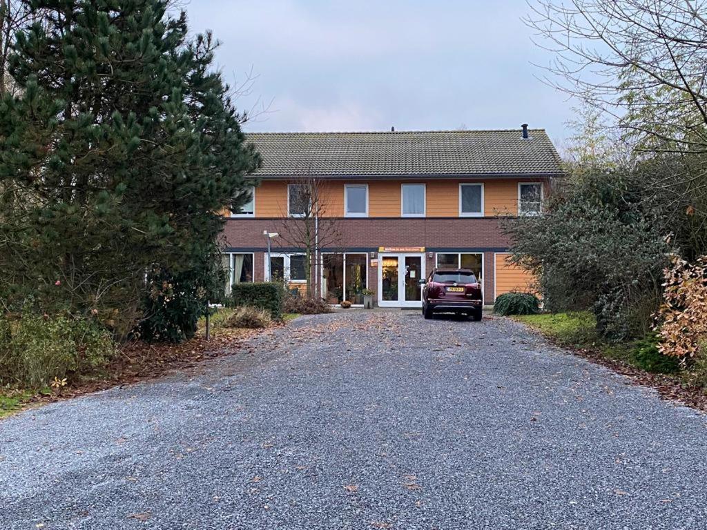 a house with a car parked in the driveway at Huis van Steen in Lelystad