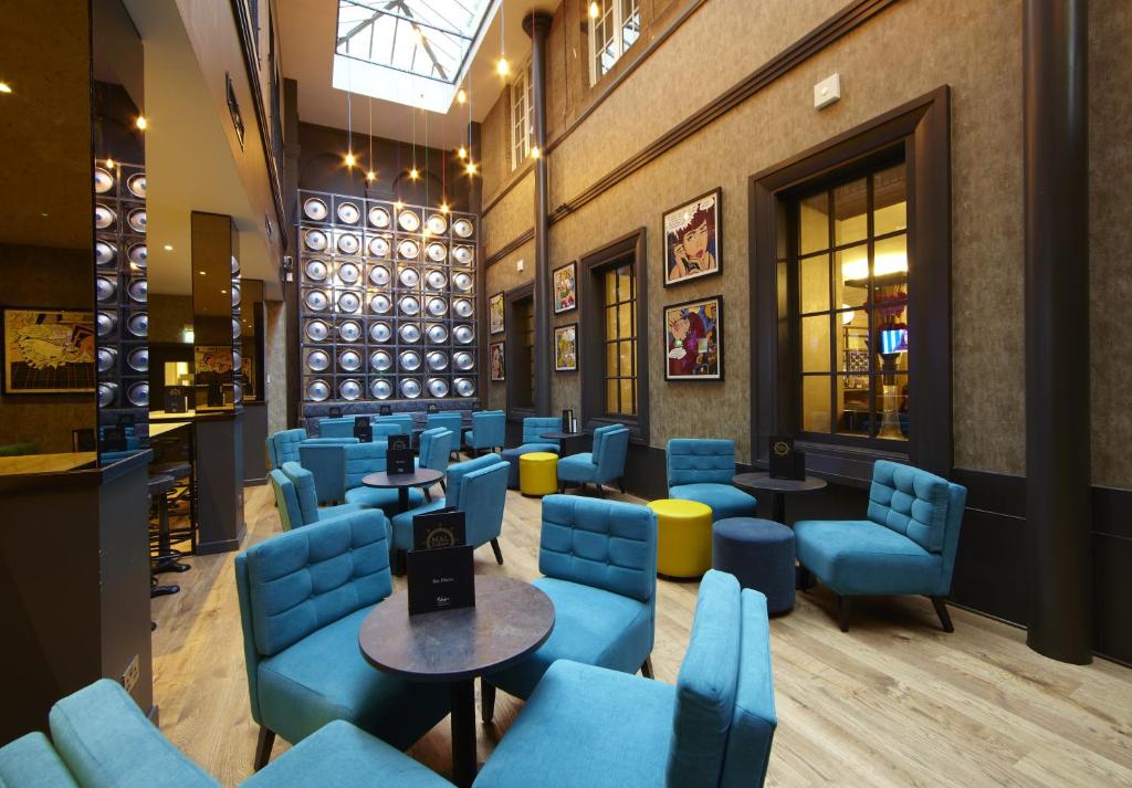 a waiting room with blue chairs and tables at Malmaison Glasgow in Glasgow