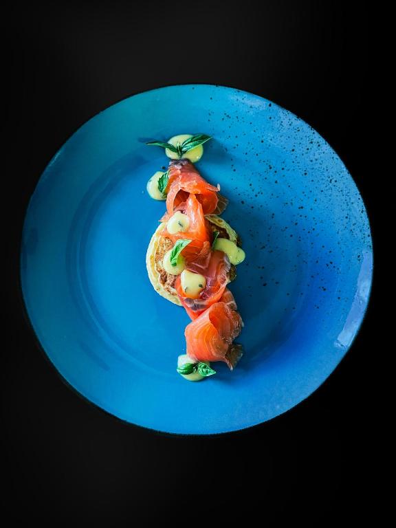 Niebieski talerz z kawałkiem sushi. w obiekcie Hotel Pradell w mieście Ortisei