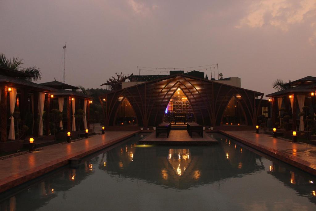un puente sobre una piscina de agua por la noche en Hotel Chulhewala en Jhānsi