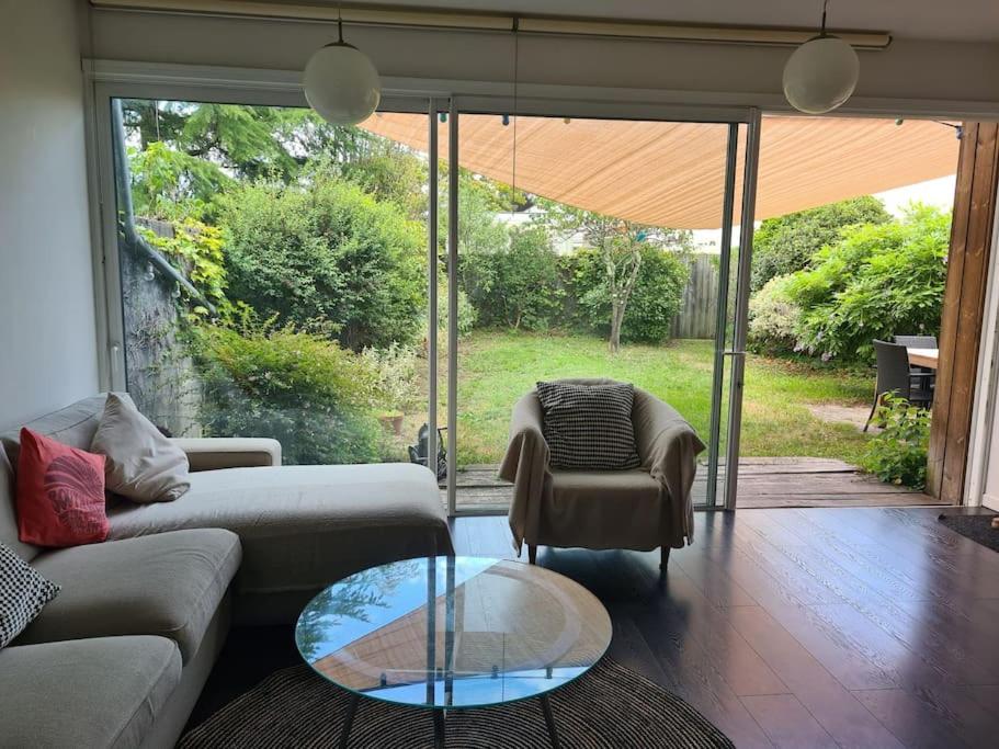un salon avec un canapé et une table en verre dans l'établissement Maison entre Bordeaux et l'eau, à Pessac
