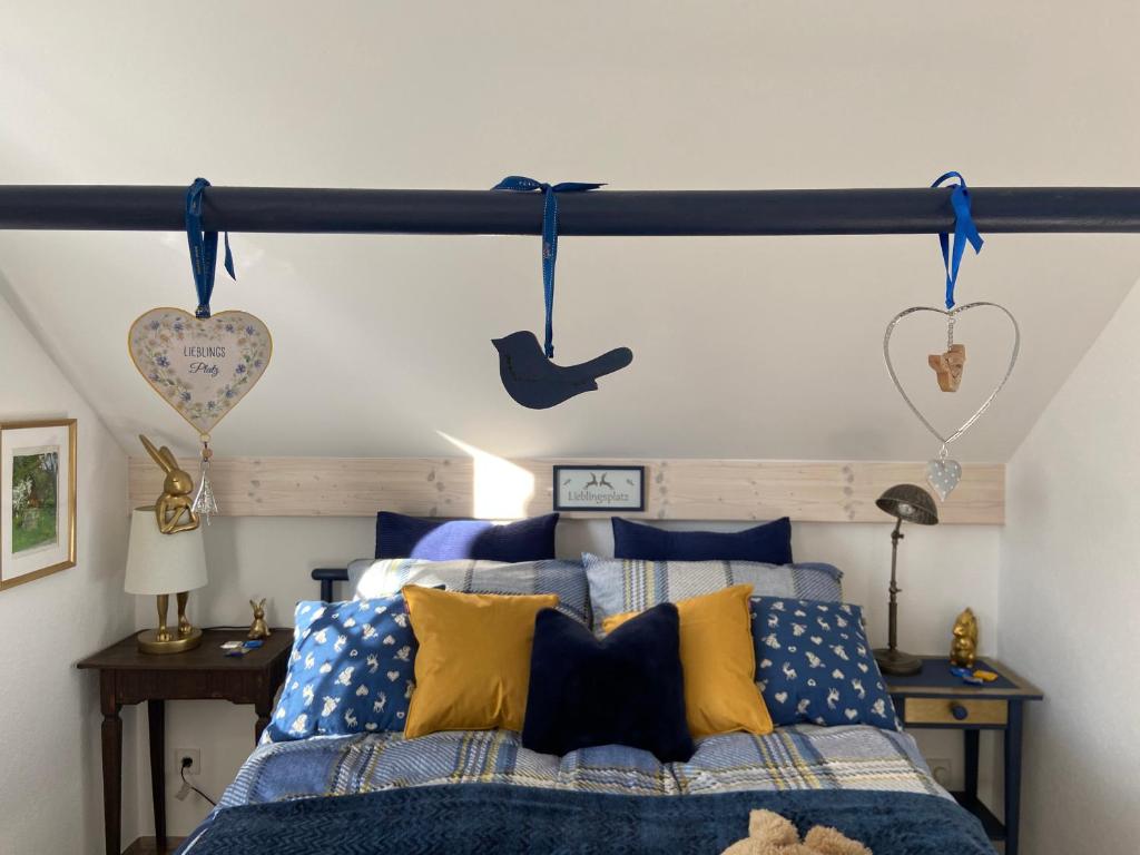 a bedroom with a bed with blue and yellow pillows at Das blaue Haus - ein Sommertraum und ein Wintermärchen in Weiler-Simmerberg