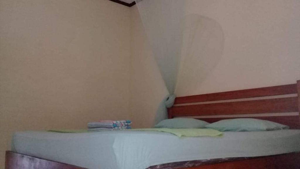 um pequeno quarto com uma cama num quarto em Tour & Travel Guide em Bukit Lawang