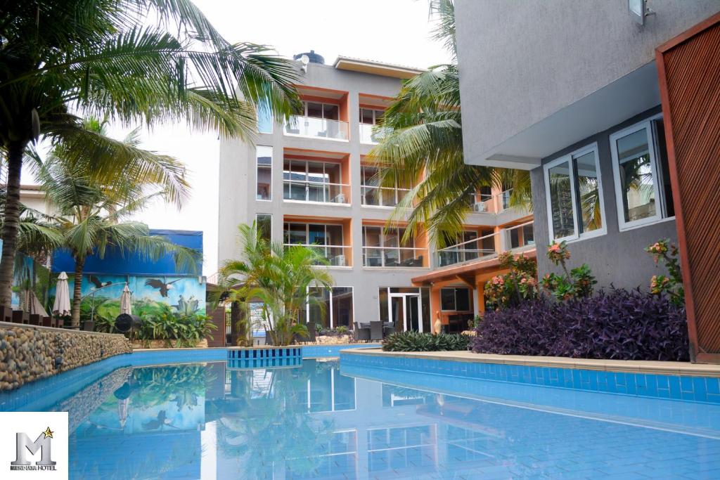 a swimming pool in front of a building at Mendiata Hotel in Accra