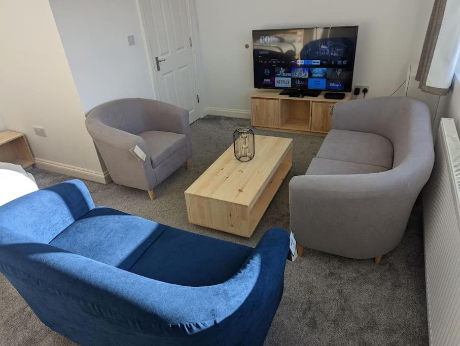 a living room with two chairs and a blue couch at Flat with great transport links in Welling