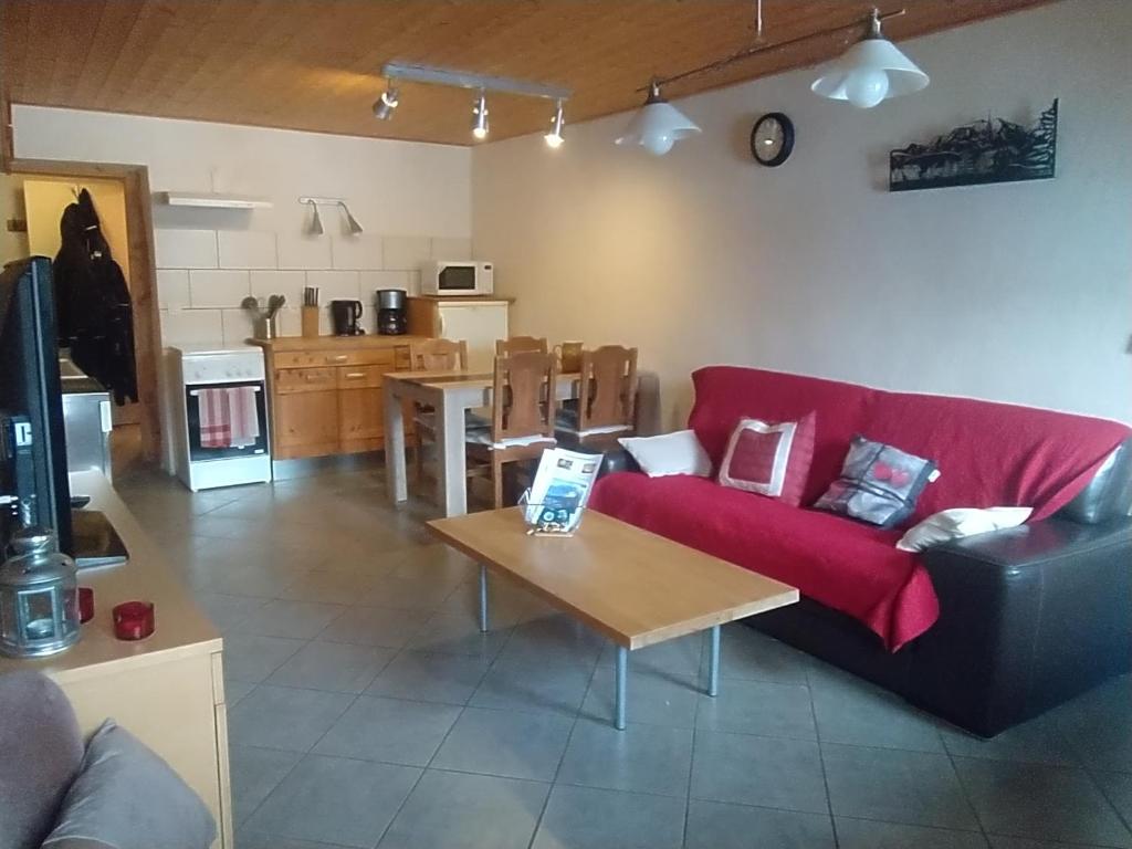 - un salon avec un canapé rouge et une table dans l'établissement La Ferme des Michaud, à Combloux