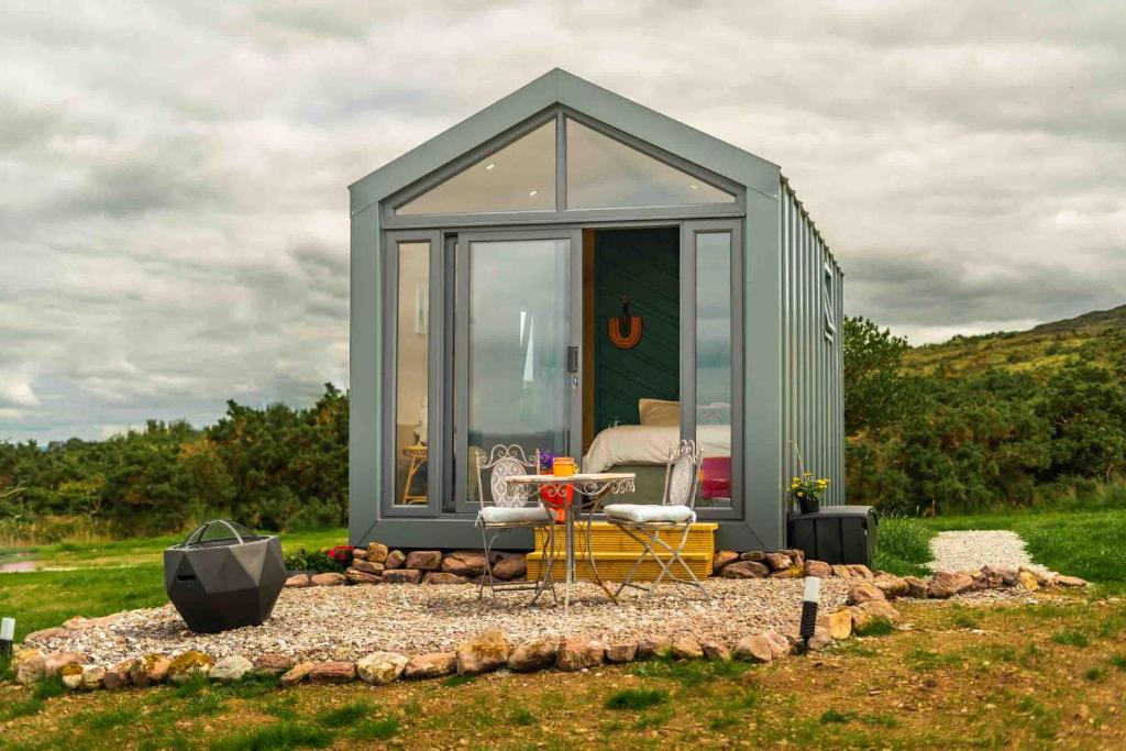 a green tiny house sitting in a field at Oaklane Glamping Cabins in Kenmare