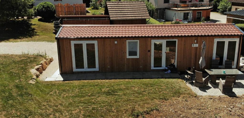 ein kleines Haus mit einem Picknicktisch und einer Bank in der Unterkunft Haus Chios in Birgland