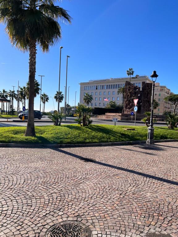 eine Kopfsteinpflasterstraße mit einer Palme und einem Gebäude in der Unterkunft B&B Zia Giuseppina & Rosa alla Riviera di Chiaia in Neapel