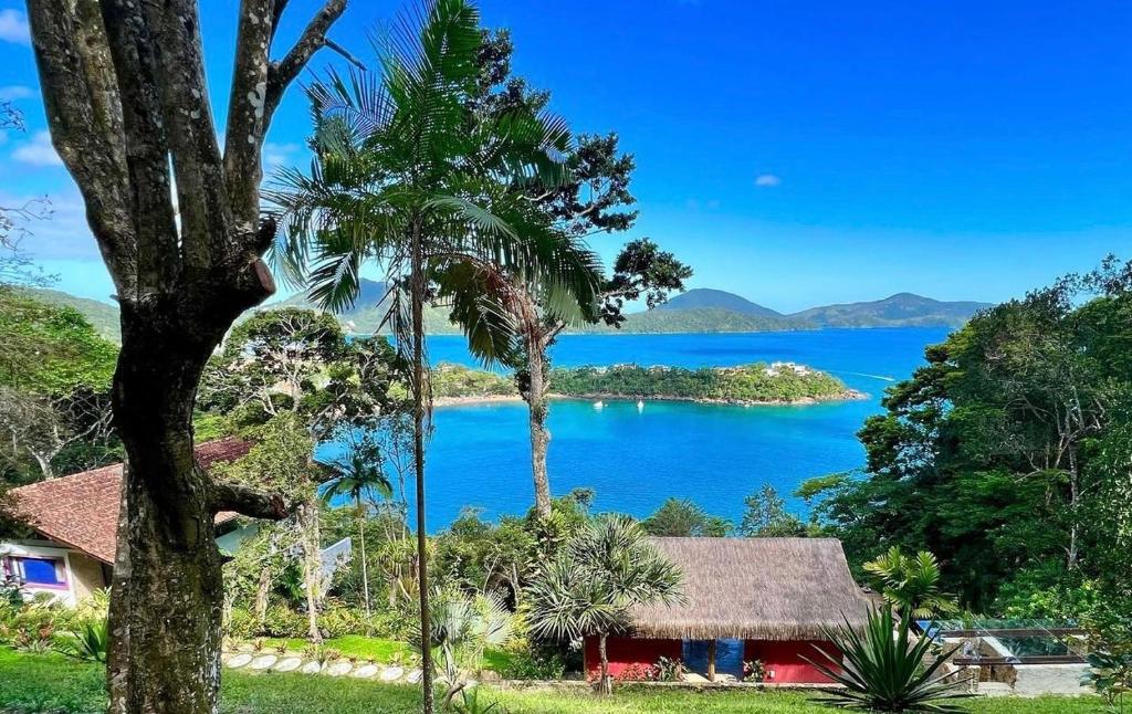 a house with a view of a body of water at Sítio Promontório - Casa Grécia in Ubatuba