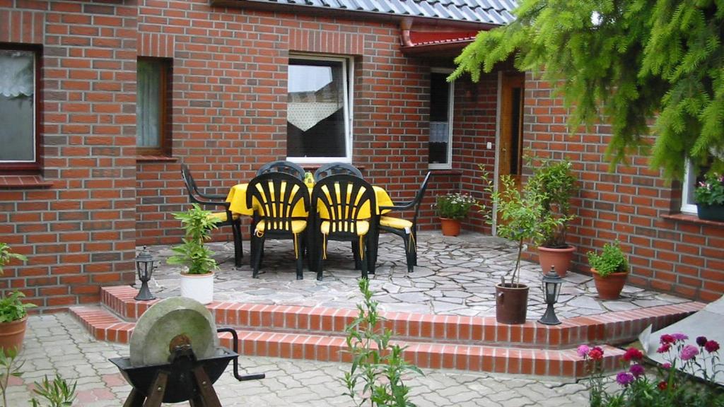 a group of black and yellow tables and chairs on a patio at Bei den Heidebirken in Nossentiner Hütte in Nossentiner Hütte