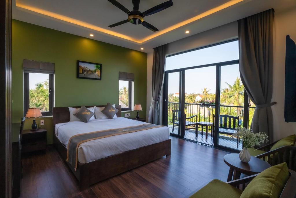 1 dormitorio con 1 cama grande y balcón en Coco Island Villa, en Hoi An