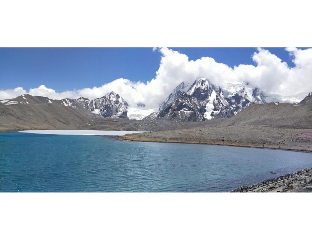 a view of a mountain range with a body of water at Cherry Village Resort, Pelling, Sikkim in Pelling