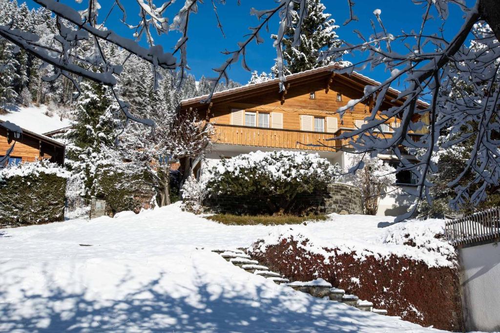 una casa con nieve en el suelo delante de ella en Chalet Grimm en Adelboden