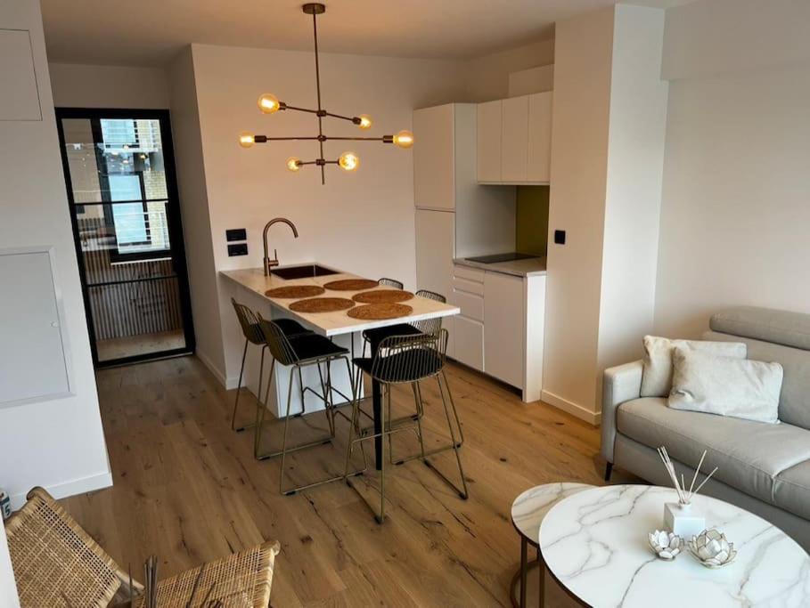 eine Küche und ein Wohnzimmer mit einem Tisch und einem Sofa in der Unterkunft Sea5 @ Nieuwpoort! Penthouse bij zee en winkels in Nieuwpoort