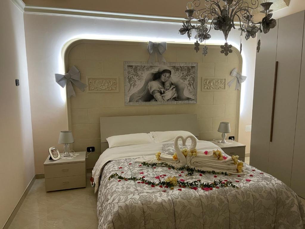 "Lu Barocco" a soli 10 min da Torre Lapillo في سان بانكرازيو سالنتينو: غرفة نوم بسرير مع صورة لامرأة