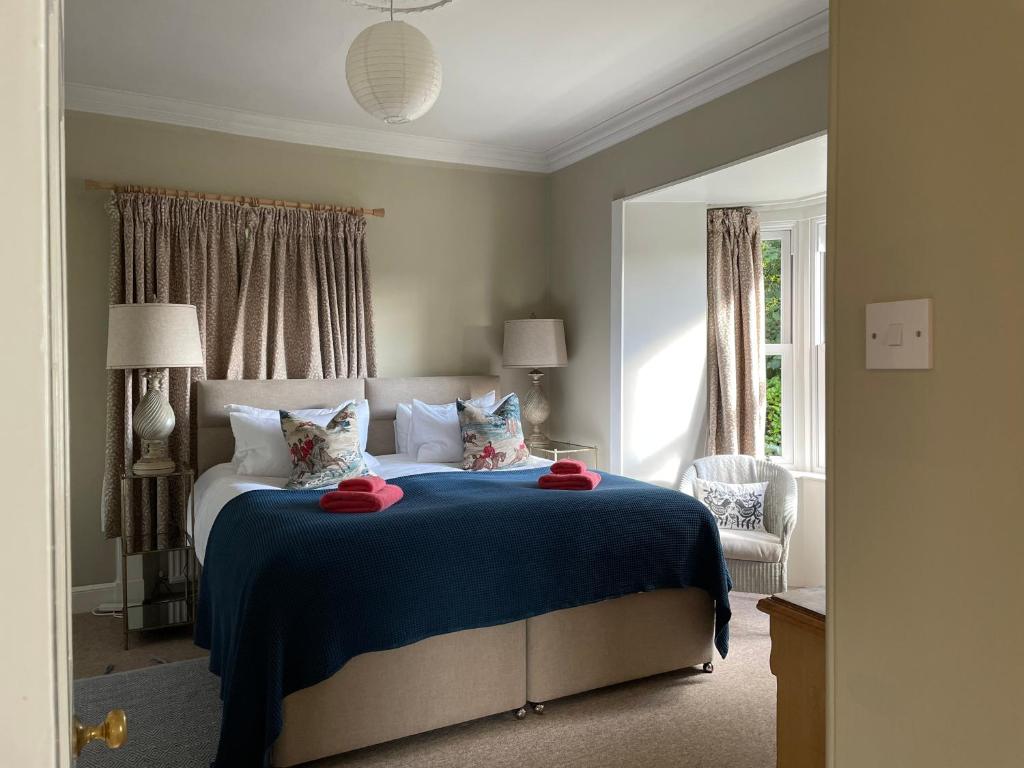 a bedroom with a large bed with a blue blanket at Princeland Lodge in Blairgowrie