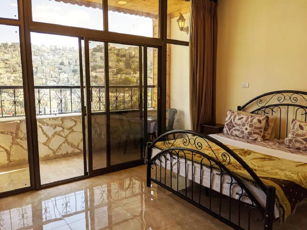 a bedroom with a bed and a large window at Khirfan Crown Houses -downtown in Amman