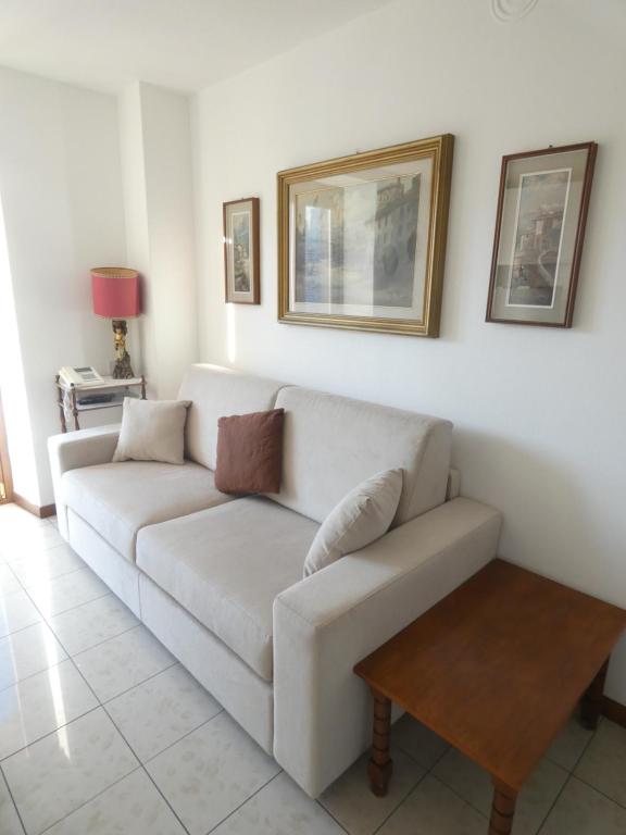 uma sala de estar com um sofá branco e uma mesa em La dimora degli Angeli em Moggio