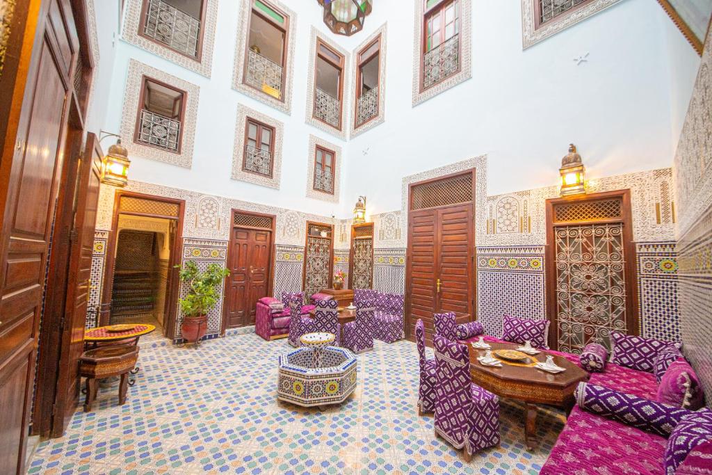 a living room with purple chairs and a table at Riad Baba in Fès