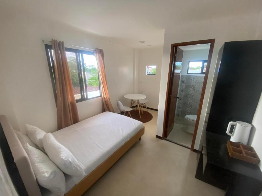 a bedroom with a bed and a bathroom with a window at Ma Lourdes Inn- Washington Street in Palompon