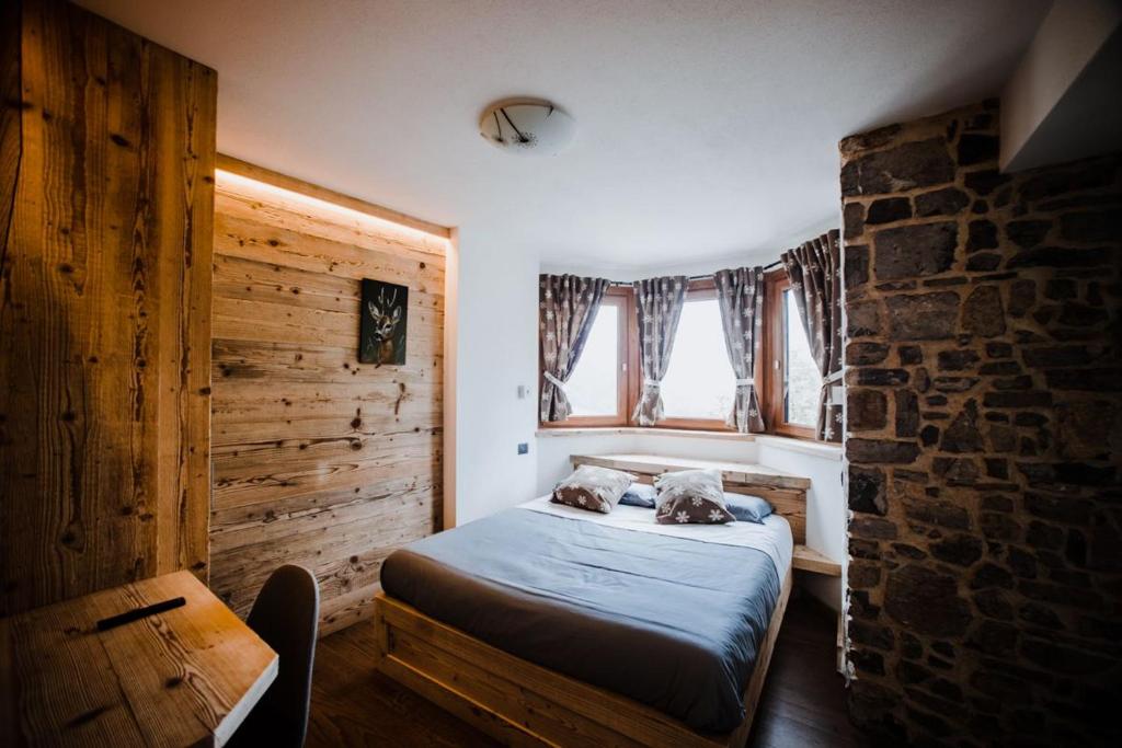 ein Schlafzimmer mit einem Bett und einer Ziegelwand in der Unterkunft Atelier della Montagna in Zambla Alta