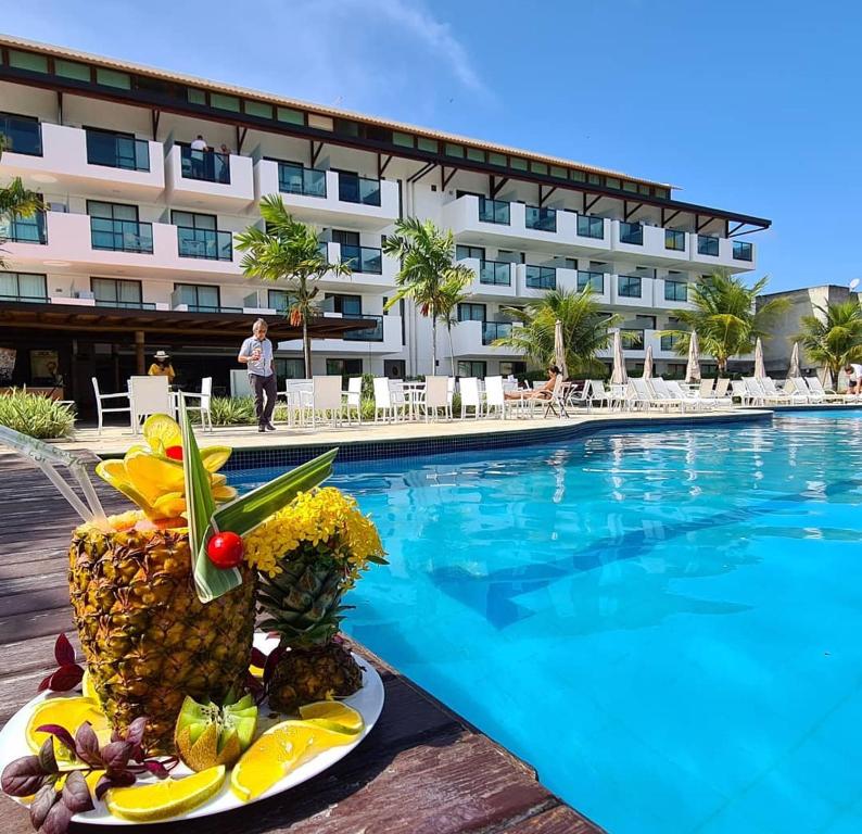 a plate of fruit next to a swimming pool at Porto de Galinhas no Laguna in Porto De Galinhas