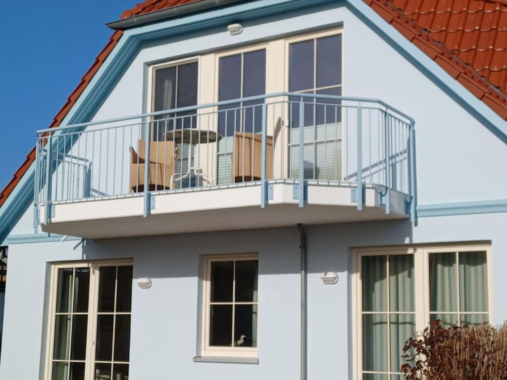 ein Haus mit einem Balkon mit Stühlen darauf in der Unterkunft An den Boddenwiesen I in Wustrow