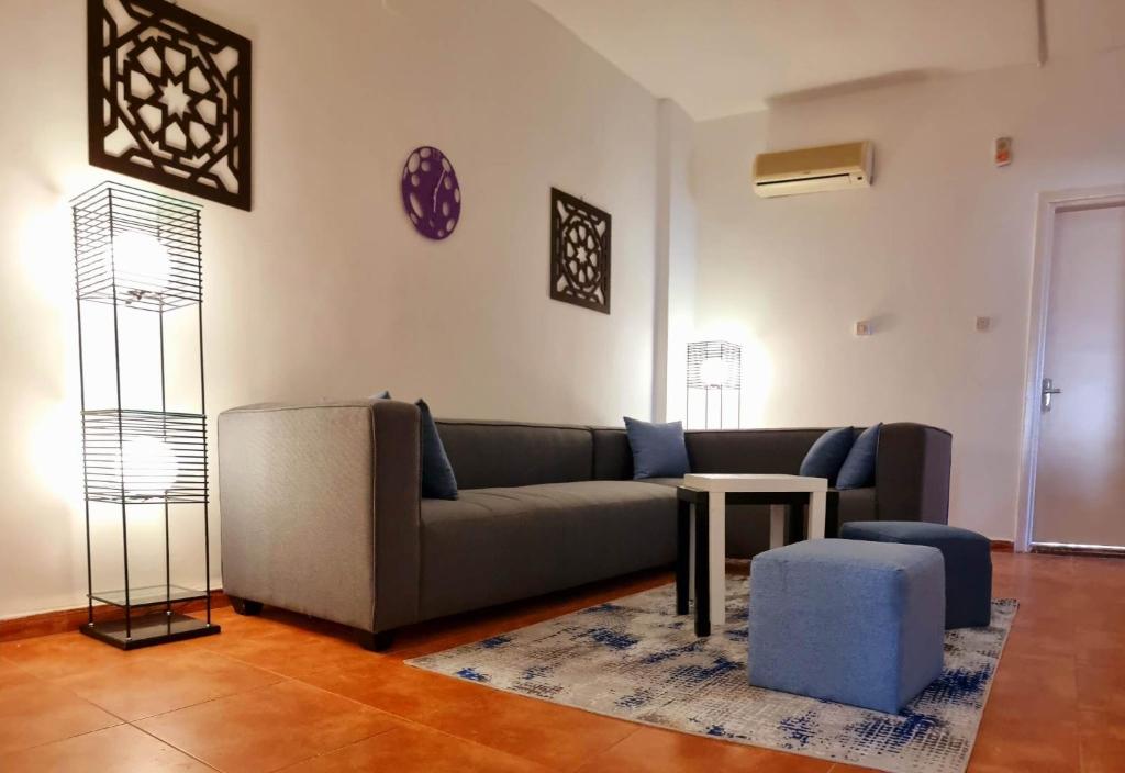 Byblos Aqaba في العقبة: غرفة معيشة مع أريكة وطاولة