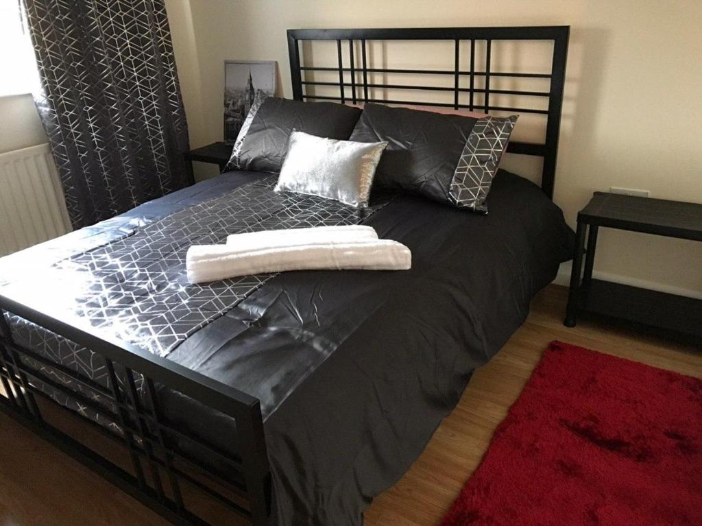 ein schwarzes Bett mit zwei Handtüchern darüber in der Unterkunft excessivEDemand home in Thorne