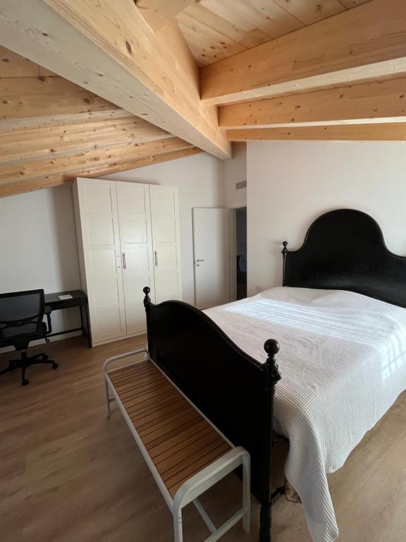 una camera con letto nero e soffitto in legno di CASA PAOLA a Sala Bolognese
