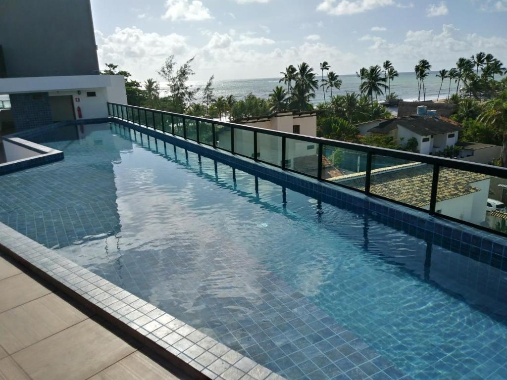 a swimming pool with a view of the ocean at Flat- maraca bech residence 2 in Ipojuca