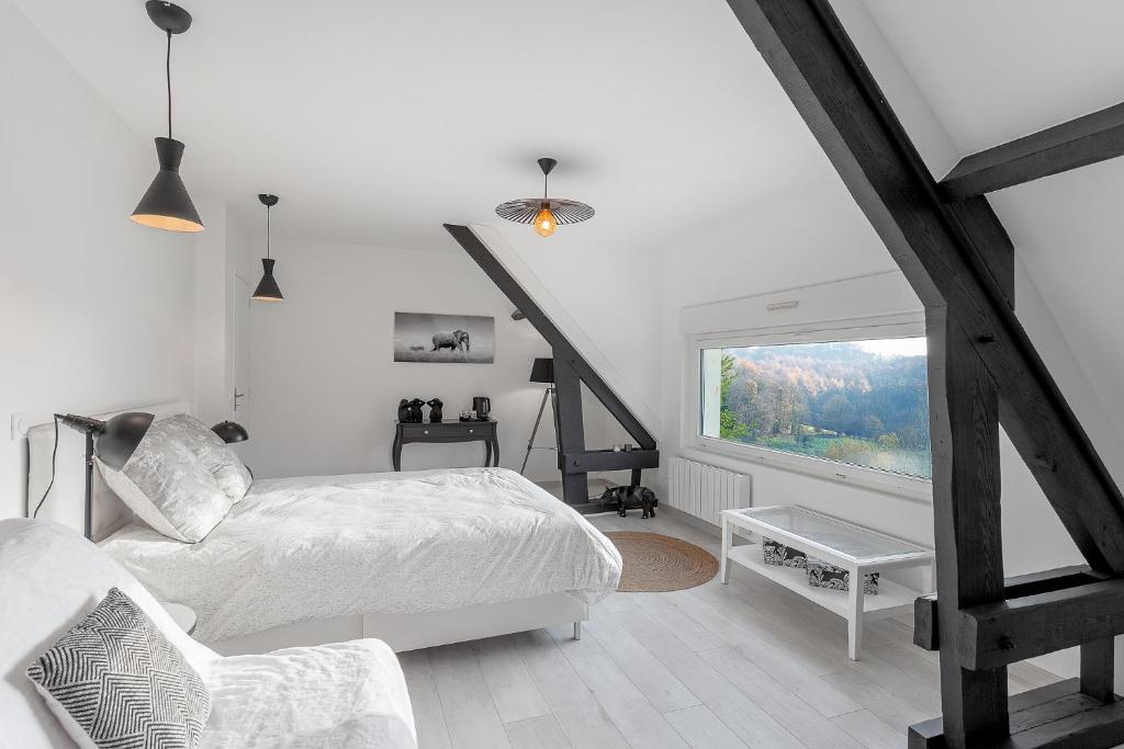 a white bedroom with a bed and a window at Au Domaine Cru in Savignies