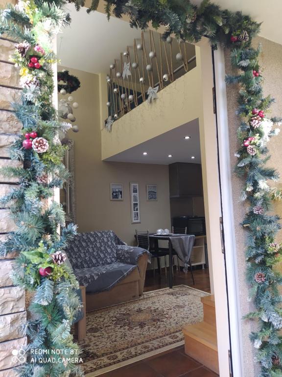 a door into a living room with christmas decorations at Agapi's Two Levels Studio in Athens