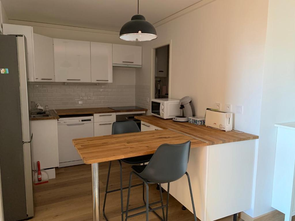 une cuisine avec une table en bois et deux chaises dans l'établissement Spacieux F3 Port Leucate, à Leucate