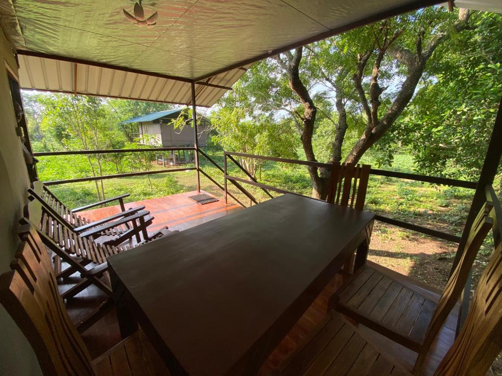 a screened in porch with a table and chairs at mango villa wilpattu in Nekattegama