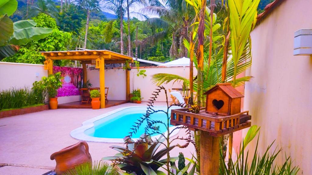 a house with a swimming pool and a bird house at Pérola de Paraty 03 com Piscina in Paraty