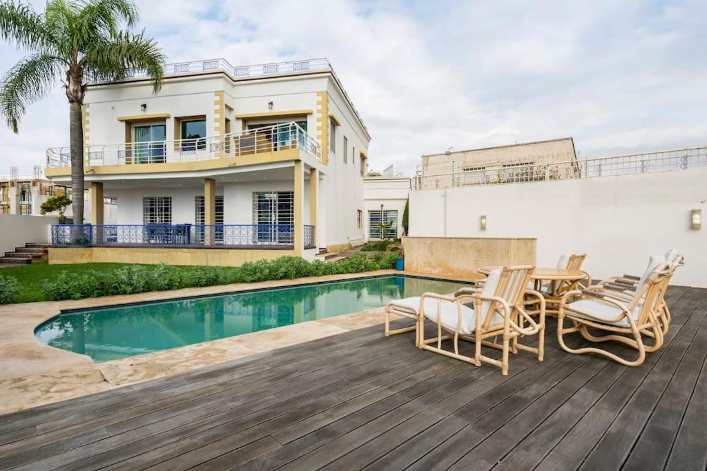 uma casa com piscina e cadeiras num deque em La villa des corsaires, vue panoramique sur Rabat em Salé