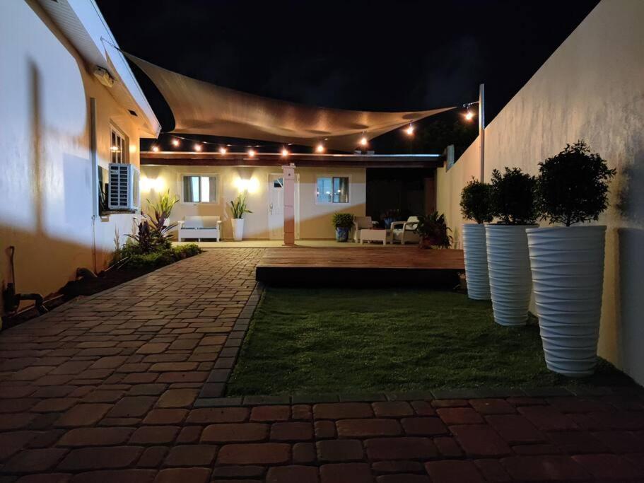 un patio con tres grandes jarrones blancos con plantas. en Palm Beach Paradise Vacation Rental en Palm-Eagle Beach