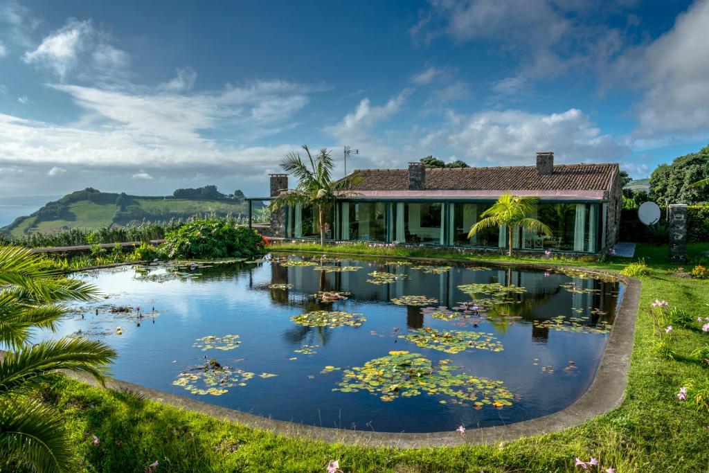 a house with a pond of water lilies at Casas do Termo in Lagoa