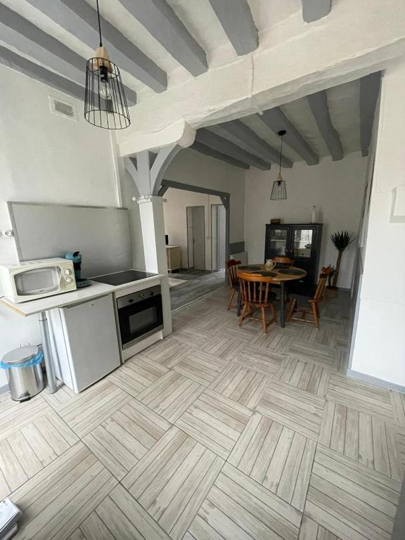 uma cozinha e sala de jantar com piso em madeira em Maison face à l'eglise em Toucy
