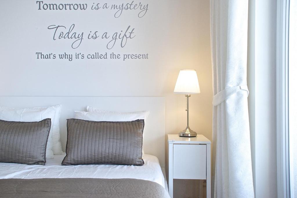 a bedroom with a bed with a sign that reads tomorrow is a mystery taking at A Nice Place to Stay Apartments in Prague