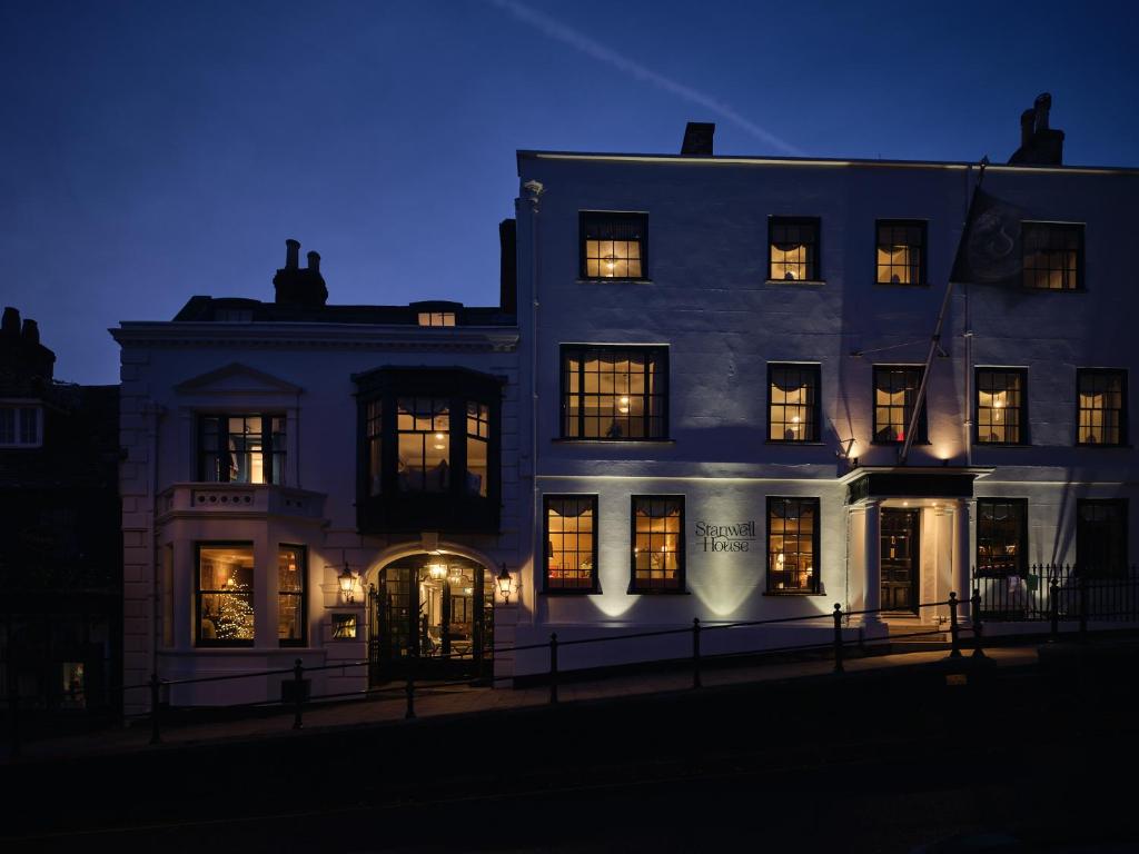 ein großes weißes Gebäude mit beleuchteten Fenstern in der Nacht in der Unterkunft Stanwell House in Lymington