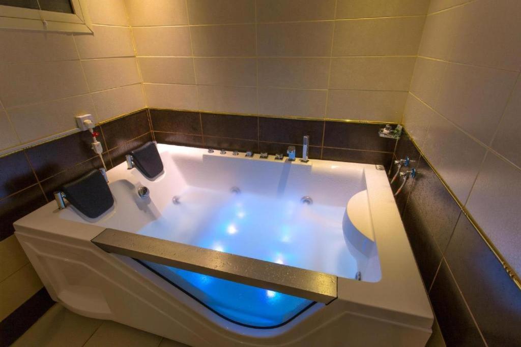 a bath tub with a blue light in a bathroom at اجنحة الماسم المخدومة -حى غرناطة in Riyadh