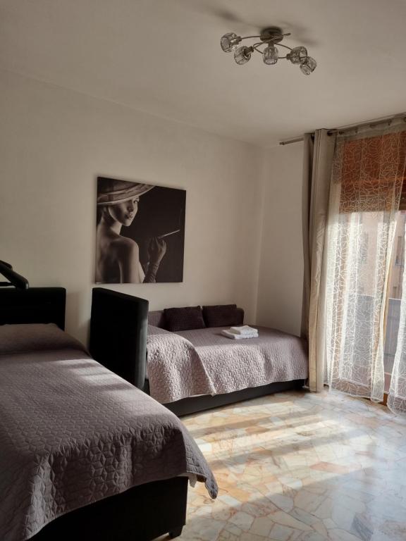 1 dormitorio con 2 camas y ventana en Alloggio Orchidea en Monfalcone