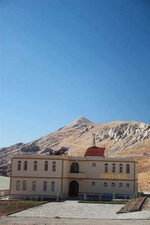 a building with a mountain in the background at Nemrut Güneş Motel in Yandere