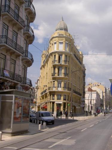a city street with buildings and a car on the road at Residencial Roxi in Lisbon