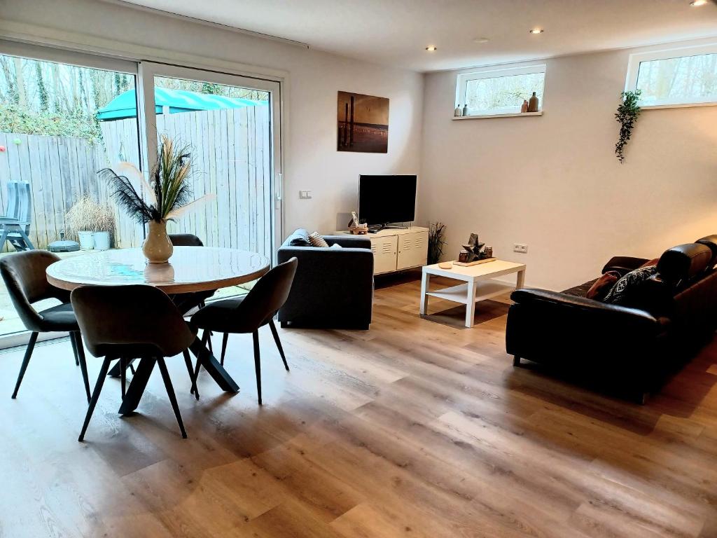 uma sala de estar com uma mesa e um sofá em Bosweg 9a, Comfortabele vakantiewoning, Centrum Zoutelande em Zoutelande