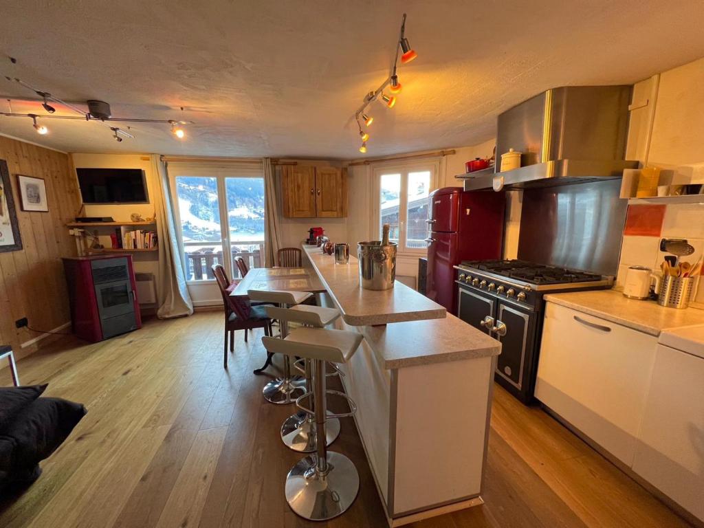 kuchnia ze stołem i kuchenką górny piekarnik w obiekcie Appartement 2pieces Hyper Centre Les Houches, proche Chamonix w mieście Les Houches